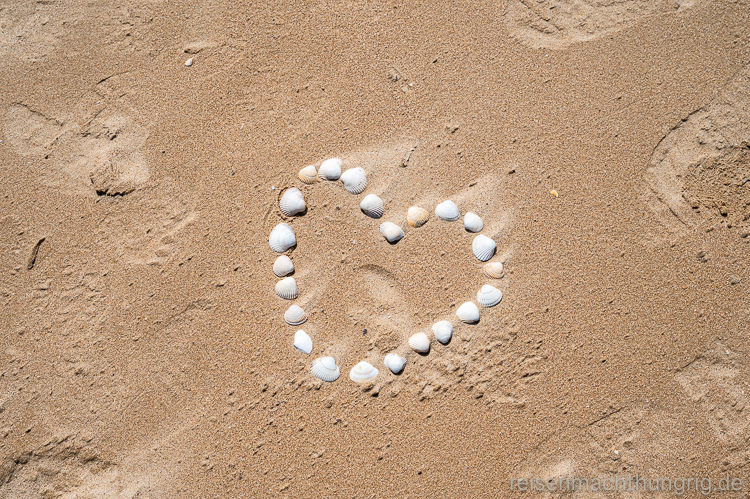 Herz aus Muscheln im Sand